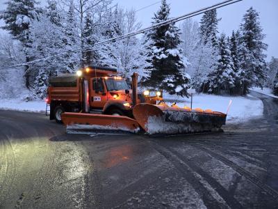 Snow plow stopped in road at night